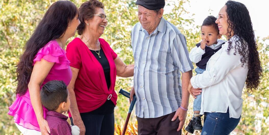 Elderly Couple Laughing with Family and Grandchildren Outdoors at an Independent Living Facility