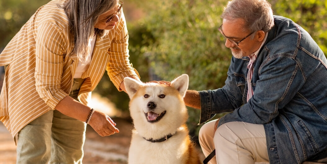 Elderly Couple Smiling While Petting Dog in Independent Living