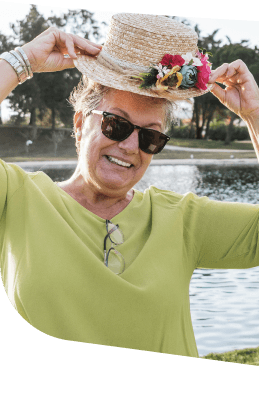 Smiling Elderly Woman Wearing Sunhat and Sunglasses Outdoors at an Independent Living Community Smiling Elderly Woman Wearing Sunhat and Sunglasses Outdoors at an Independent Living Community