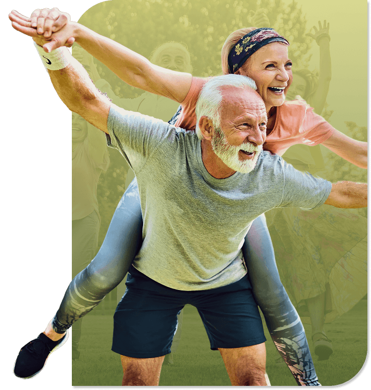 Joyful Elderly Couple Playing Piggyback Outdoors during Active Recreation at an Independent Living Community Joyful Elderly Couple Playing Piggyback Outdoors during Active Recreation at an Independent Living Community