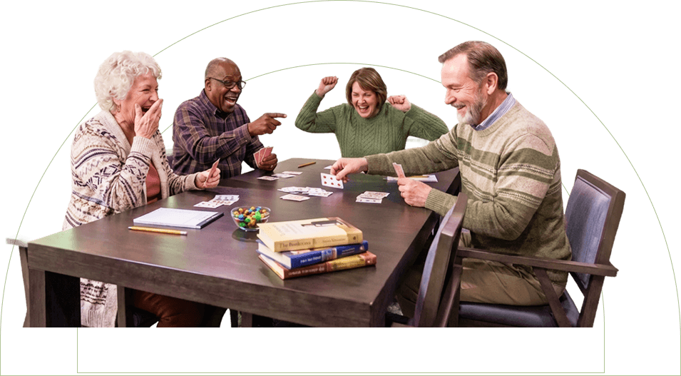 Group of Elderly Friends Laughing While Playing Cards Together at an Independent Living Community Group of Elderly Friends Laughing While Playing Cards Together at an Independent Living Community