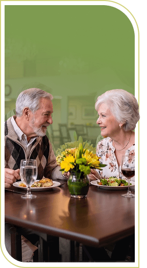 Elderly Couple Enjoying a Pleasant Dinner Together with Fresh Flowers at Independent Living