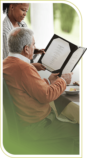 Female Server Presenting Menu to Elderly Man Dining at an Independent Living Community