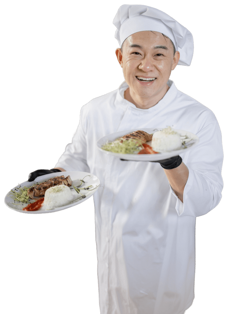 Smiling Male Chef Presenting Two Plates of Gourmet Food at an Independent Living Community Smiling Male Chef Presenting Two Plates of Gourmet Food at an Independent Living Community