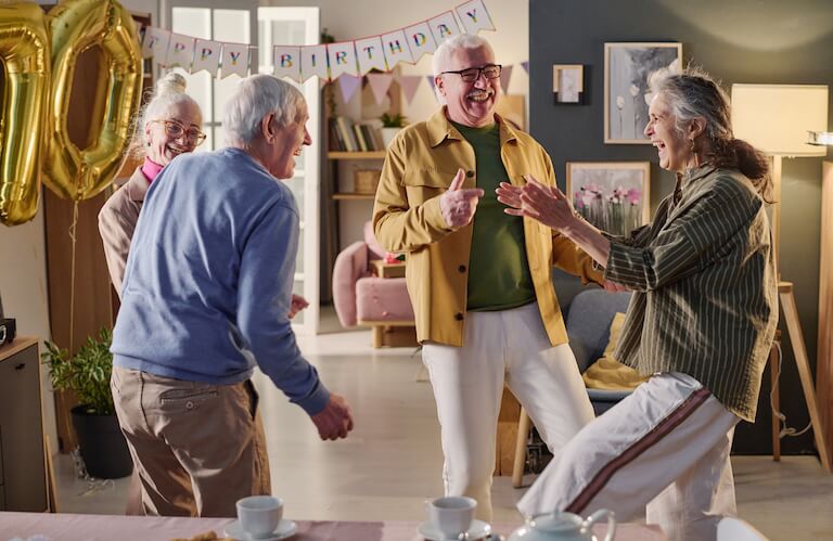 Group of Elderly Friends Dancing at a Birthday Celebration Together at an Independent Living Community