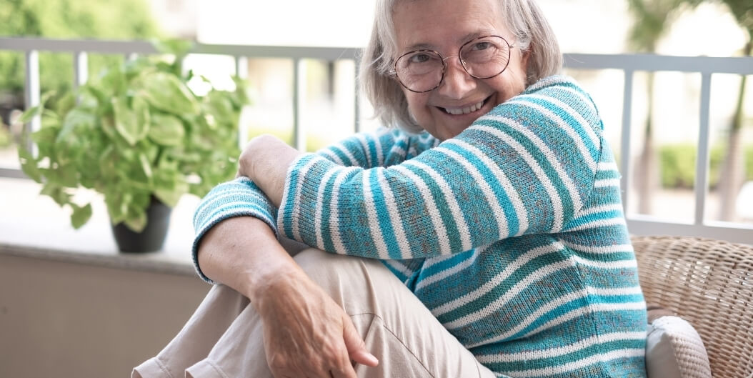 Elderly Woman Relaxing on Porch at Independent Living Facility